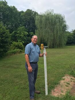 Keith Burgess posing with the ruler used to measure elevation.  Picture taken at Clover Forest Farm by Sebastian Volcker