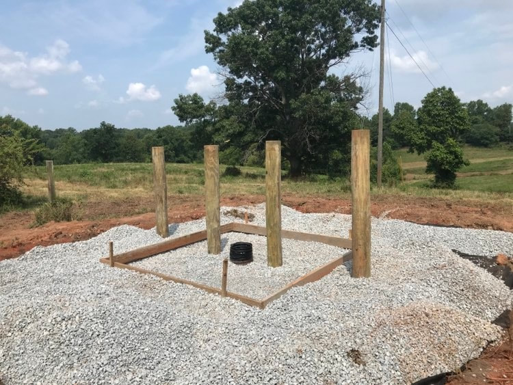 Four post in line, in gravel in preparation of the concrete slab which will serve as trough base.  Picture taken at Clover Forest Farm by Sebastian Volcker